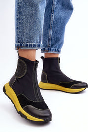 Ravena Leather Sport-Zip Boots with bold yellow sole, featuring a modern silhouette and front zipper, styled with blue denim jeans.