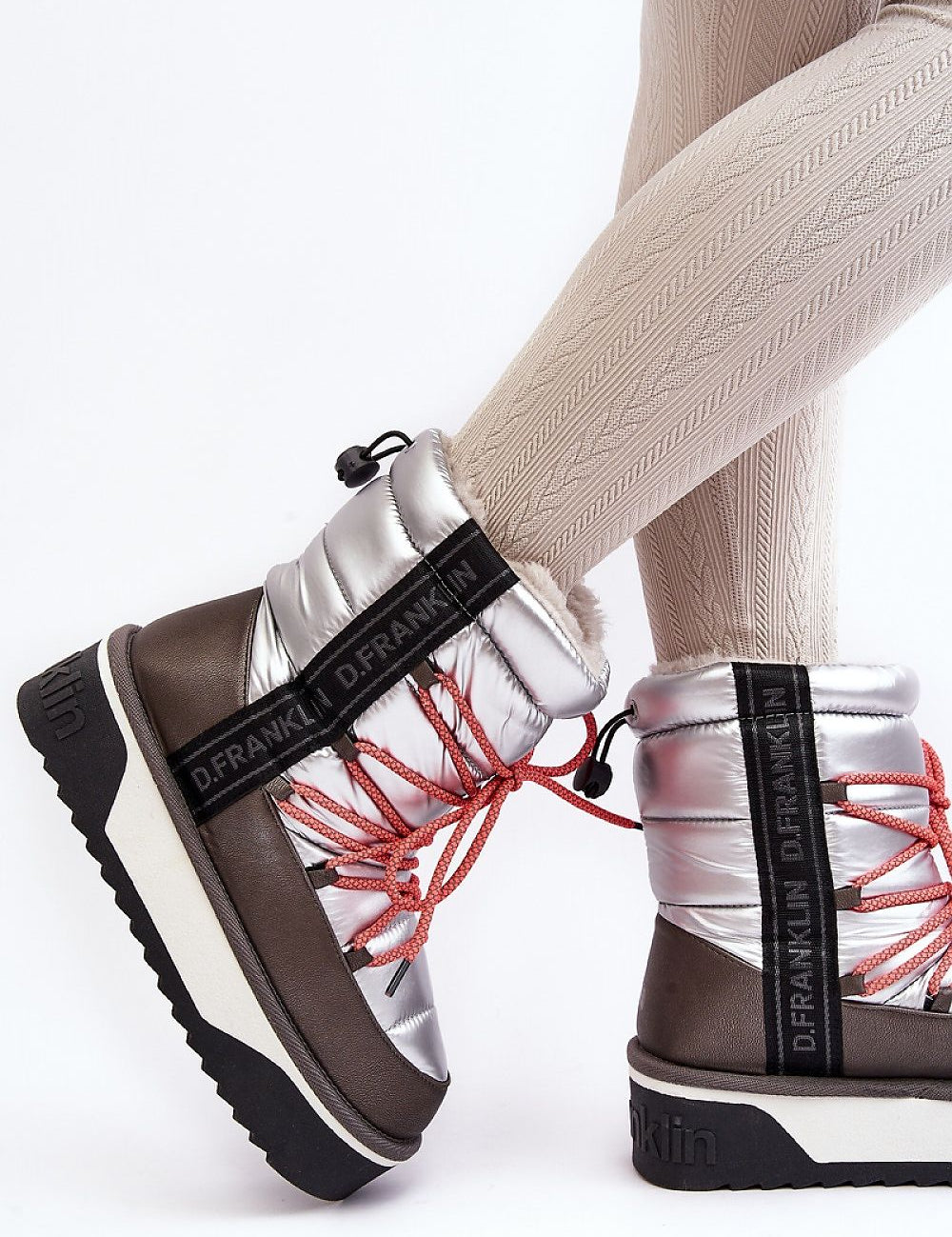 Fashionable silver snow boots with red laces and thick sole, perfect for winter style and comfort.