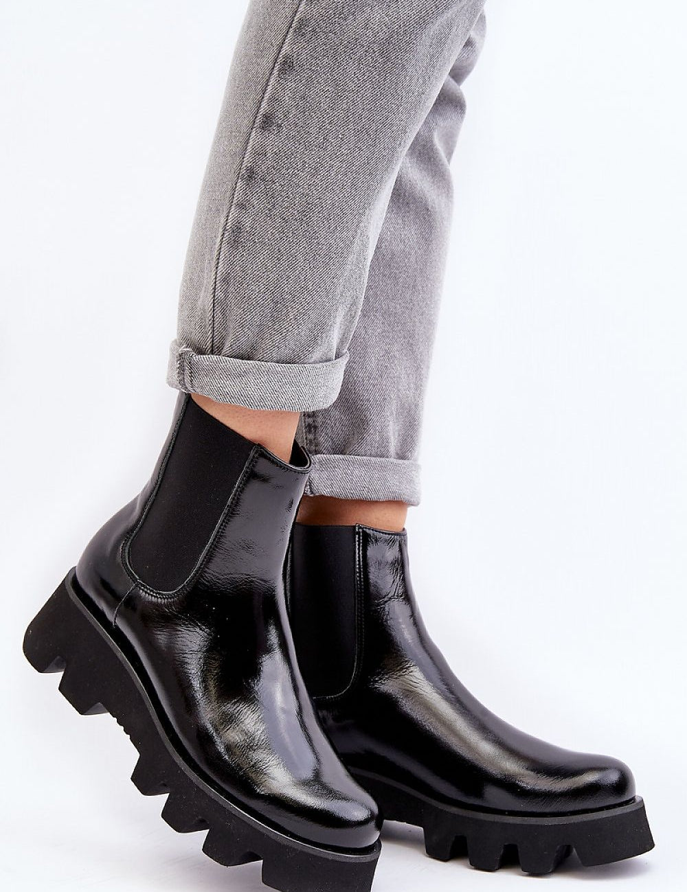 Black leather platform Jodhpur boots with grooved sole and rounded toe, worn with rolled grey jeans for stylish comfort.