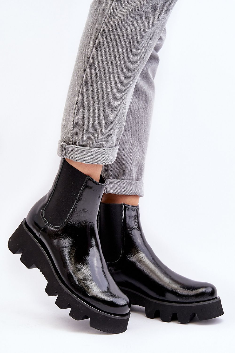 Black leather platform Jodhpur boots with grooved sole and rounded toe, worn with rolled grey jeans for stylish comfort.