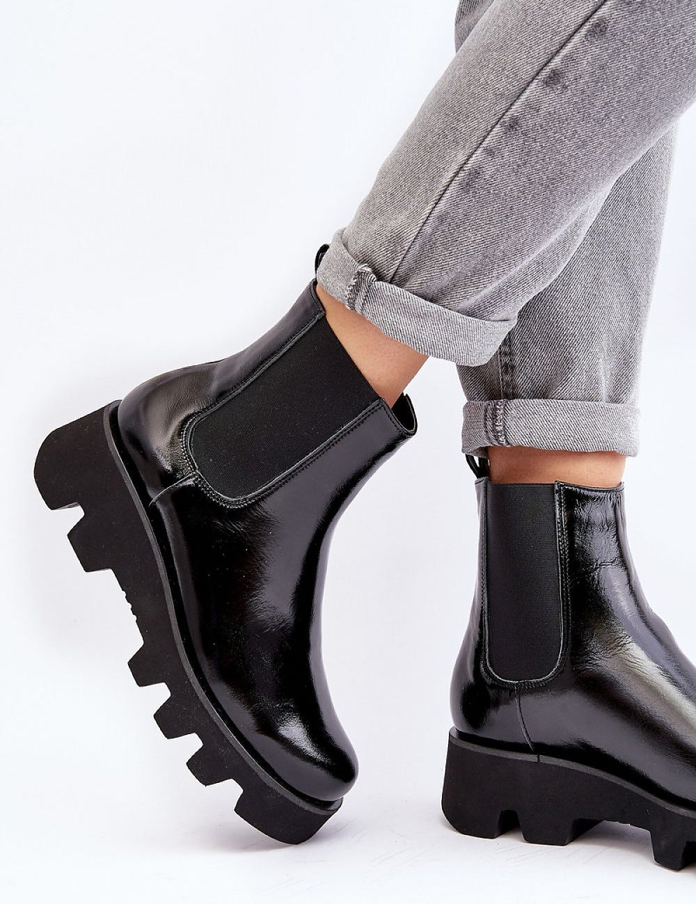 Black leather platform Jodhpur boots with grooved sole and flat heel, worn with rolled-up jeans, showcasing a modern silhouette.