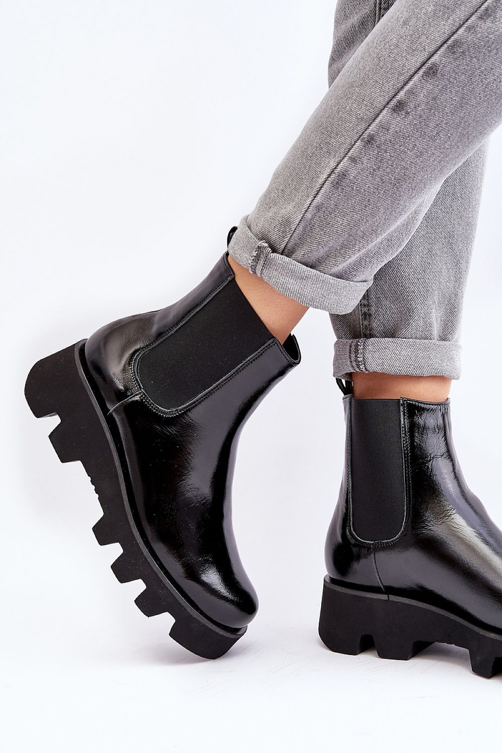Black leather platform Jodhpur boots with grooved sole and flat heel, worn with rolled-up jeans, showcasing a modern silhouette.