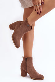 Woman wearing brown eco suede ankle boots with block heel and side zipper, showcasing versatile day-to-night style.
