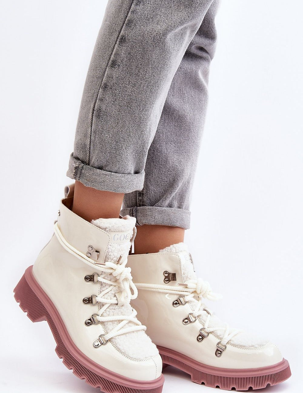 Person wearing Larkwood Trapper Boots with natural leather and sheepskin details, featuring a lace-up design and durable flat heel.