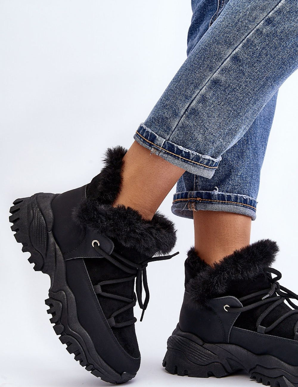 Velora faux fur-lined winter sneakers in black, trapper-style, eco leather, with lacing and platform heel, paired with denim jeans.