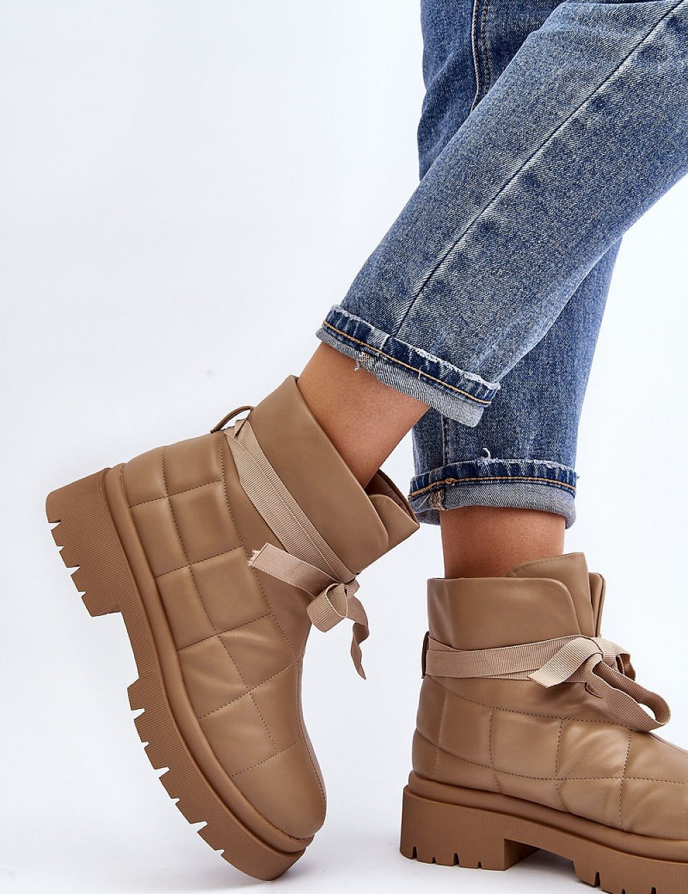 Woman wearing Velda Quilted Slip-On Winter Boots in eco leather with jeans, showcasing ankle-high design and quilted upper.