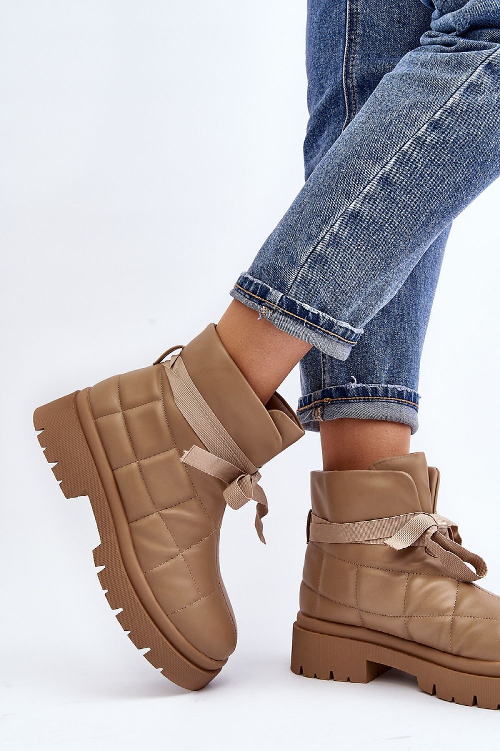 Woman wearing Velda Quilted Slip-On Winter Boots in eco leather with jeans, showcasing ankle-high design and quilted upper.