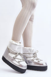 Woman wearing Yllora silver platform snow boots with foam lining, thick textile, and eco-leather exterior, side view.