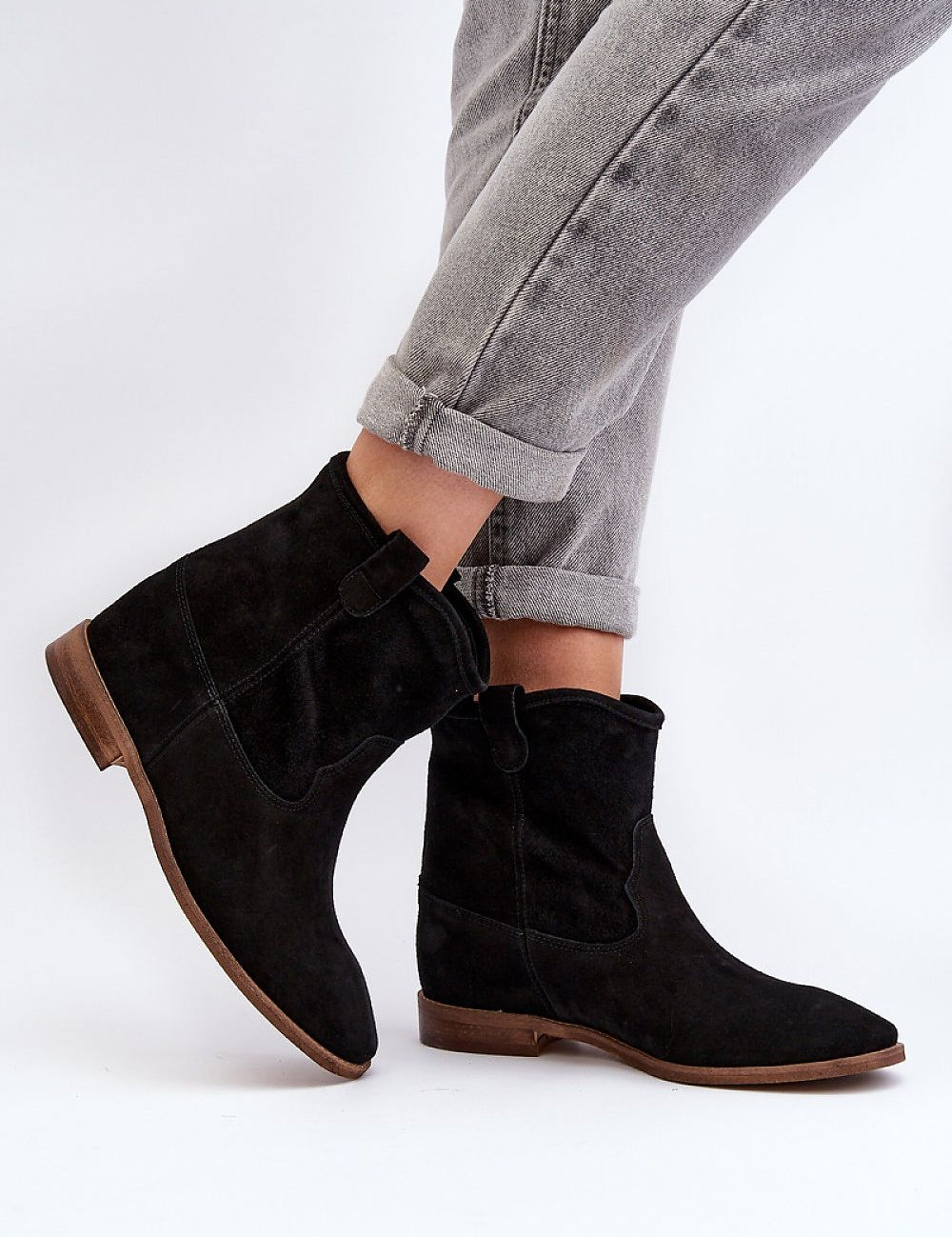 Woman wearing Meredia suede slip-on flat boots with a concealed wedge and rounded toe, perfect for casual and minimalist chic outfits.