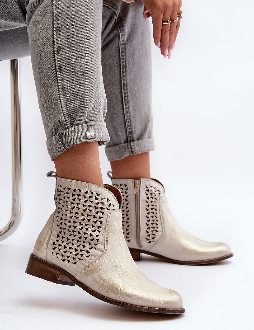 Velenna Openwork Leather Zip Boots with decorative cutouts, side zipper, and low heel, styled with cuffed jeans for casual chic look.