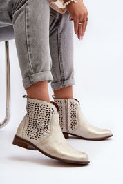 Velenna Openwork Leather Zip Boots with decorative cutouts, side zipper, and low heel, styled with cuffed jeans for casual chic look.