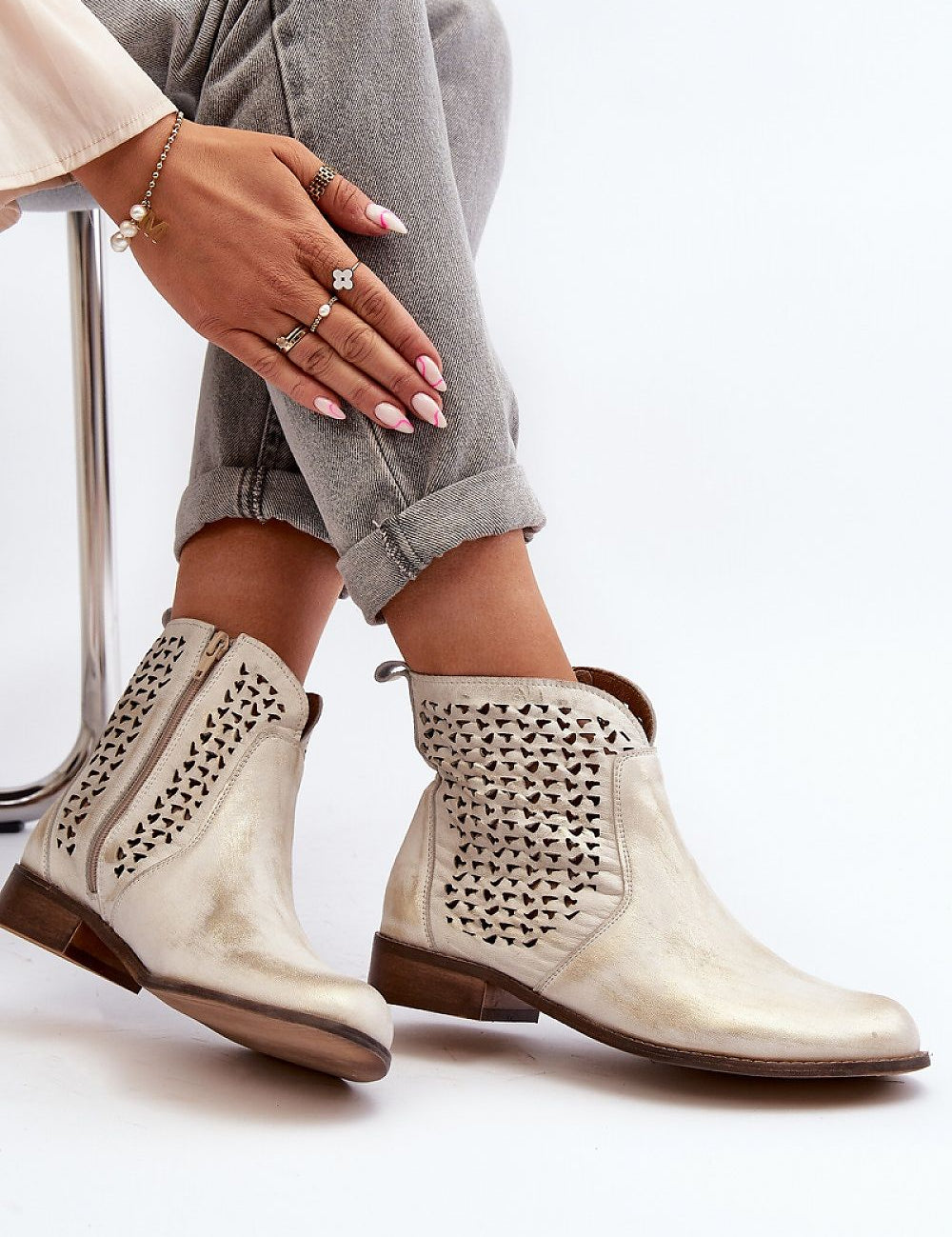 Velenna openwork leather zip boots with decorative detailing and low-profile heel, styled with jeans for trendy, comfortable wear.