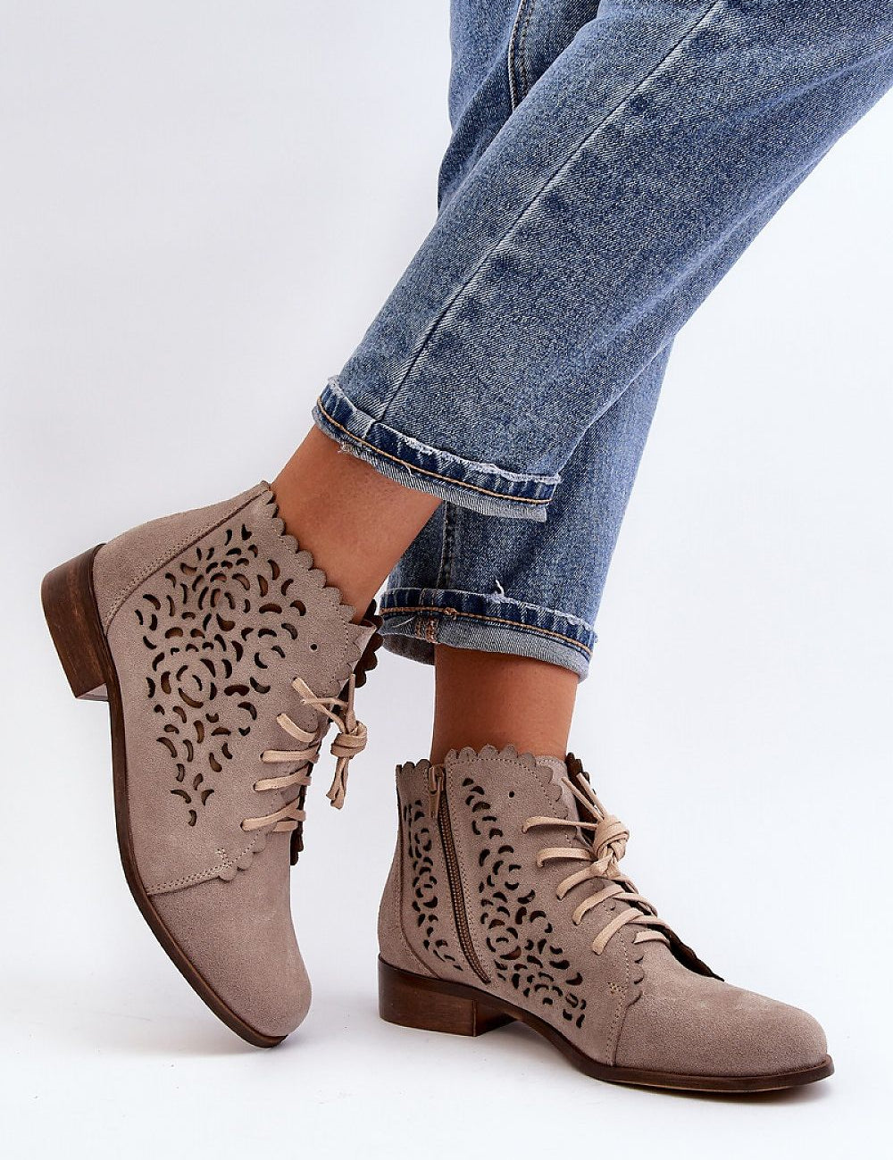 Caressa suede lace-up flat ankle boots with laser-cut design, worn with jeans, featuring low shaft, flat sole, side zipper, and laces.