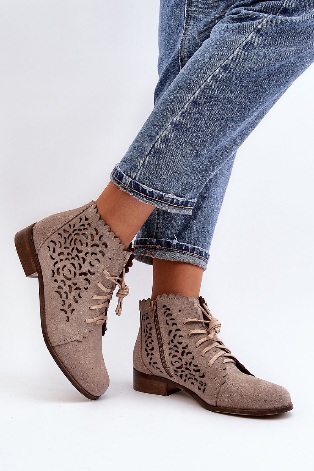 Caressa suede lace-up flat ankle boots with laser-cut design, worn with jeans, featuring low shaft, flat sole, side zipper, and laces.
