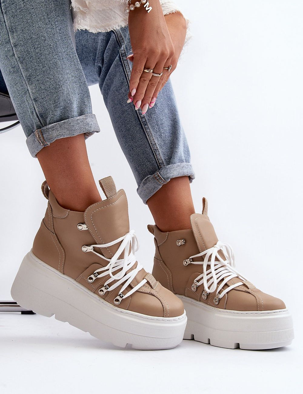 Woman wearing Ermelle Sculpted Platform Sneakers in beige with white laces, showcasing modern fashion with high-platform design.