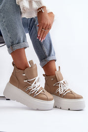 Woman wearing Ermelle Sculpted Platform Sneakers in beige with white laces, showcasing modern fashion with high-platform design.