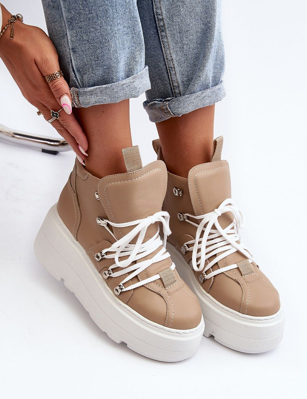 Woman wearing Ermelle Sculpted Platform Sneakers with beige leather and white laces, showcasing the bold platform and modern style.