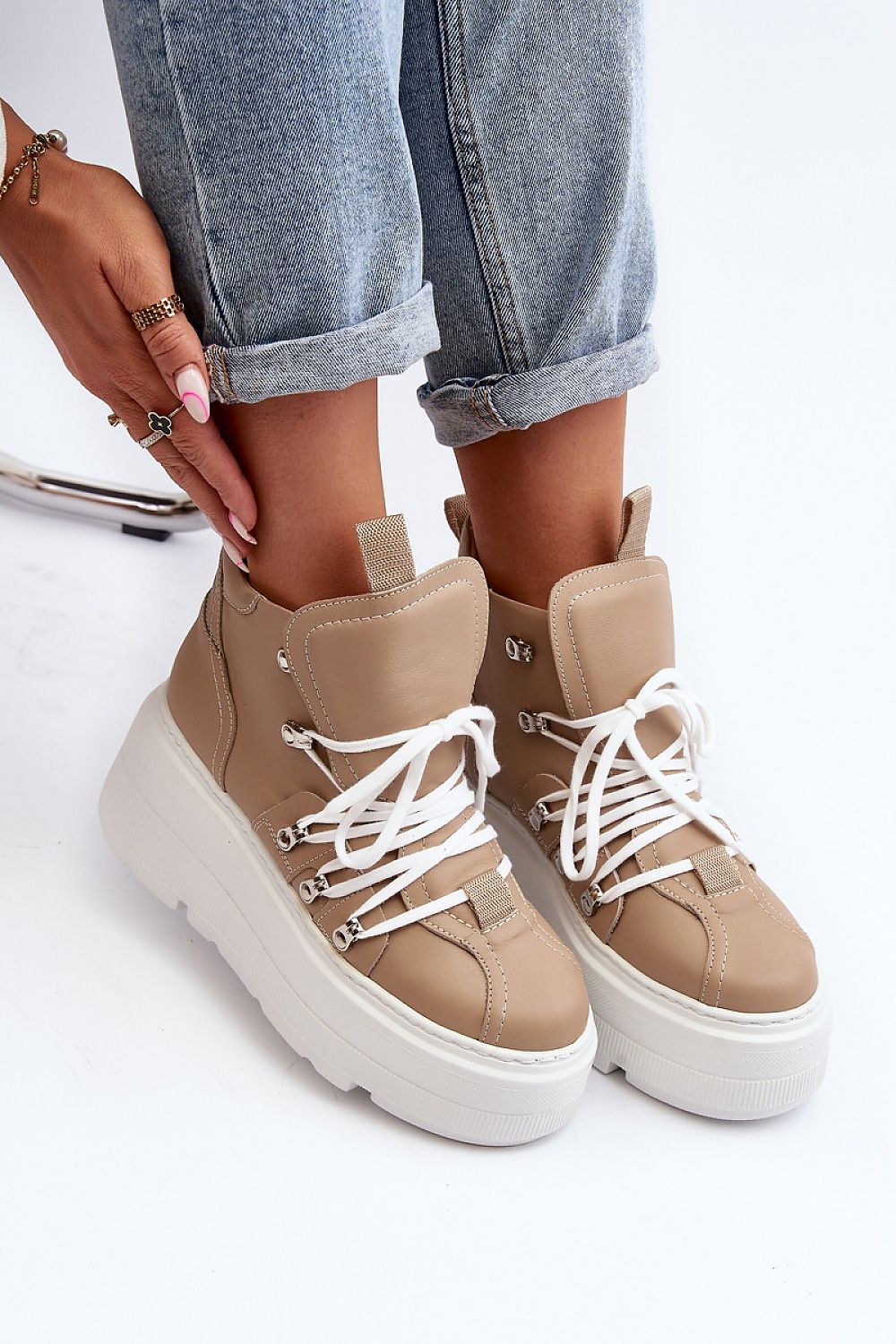 Woman wearing Ermelle Sculpted Platform Sneakers with beige leather and white laces, showcasing the bold platform and modern style.