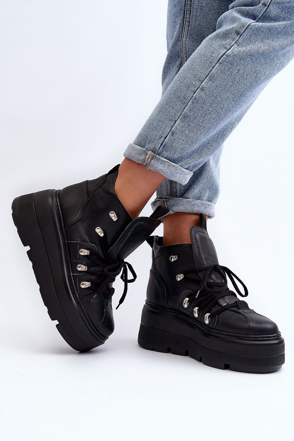 Person wearing Ermelle Sculpted Platform Sneakers in black leather with bold platform and high upper.
