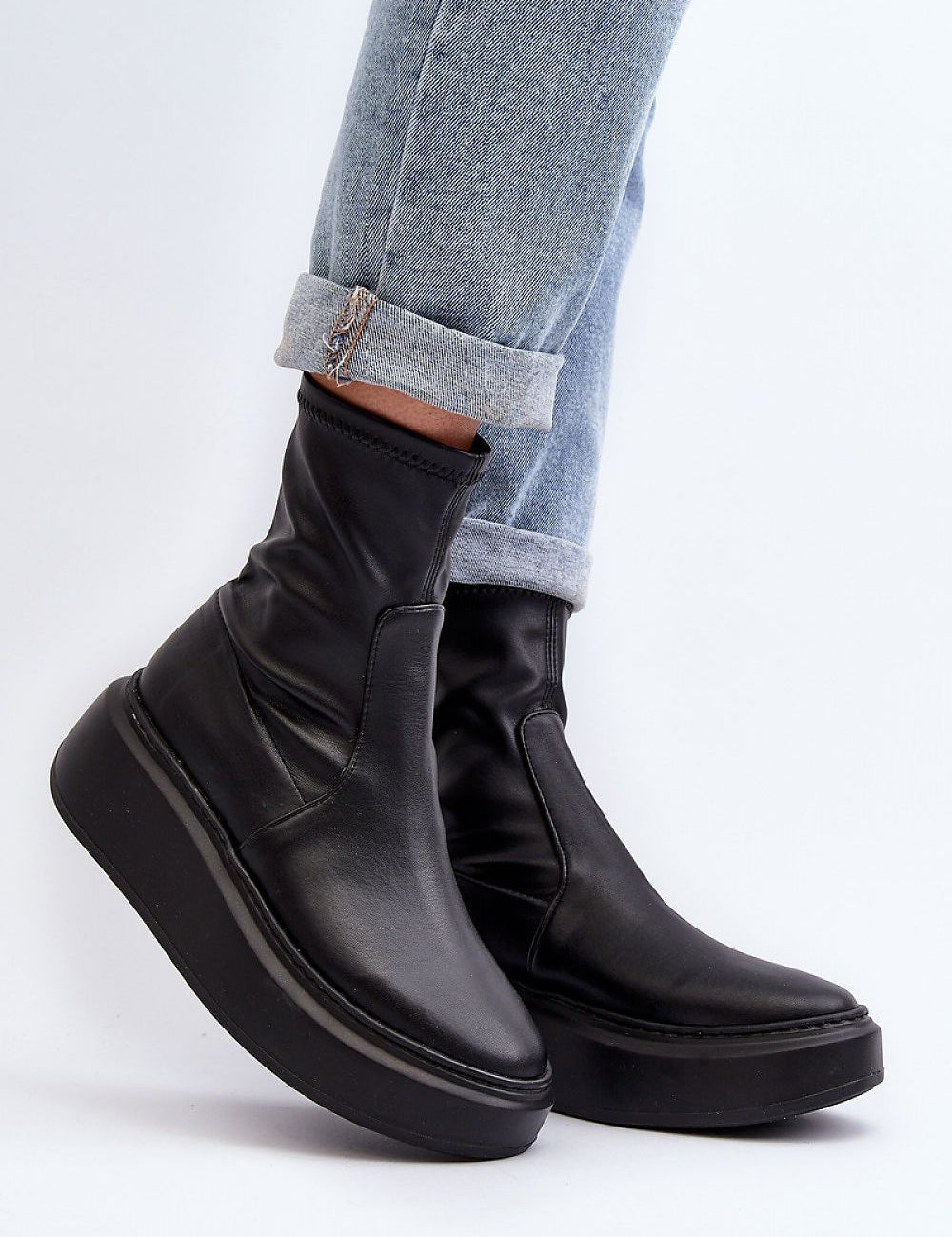Zovela leather platform slip-on boots with 6 cm heel, sleek silhouette, and rounded toe, paired with cuffed denim jeans.