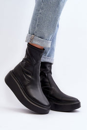 Zovela leather platform slip-on boots with 6 cm heel, sleek silhouette, and rounded toe, paired with cuffed denim jeans.