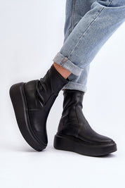 Black Zovela Leather Platform Slip-On Boots with 6 cm heel, worn with rolled jeans, showcasing modern style and comfort.
