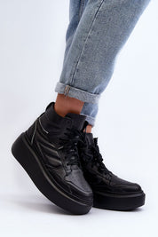 Black Valonne Leather Platform Trainers with 7cm heel and thick base, ankle-high, paired with rolled-up jeans for a stylish look.