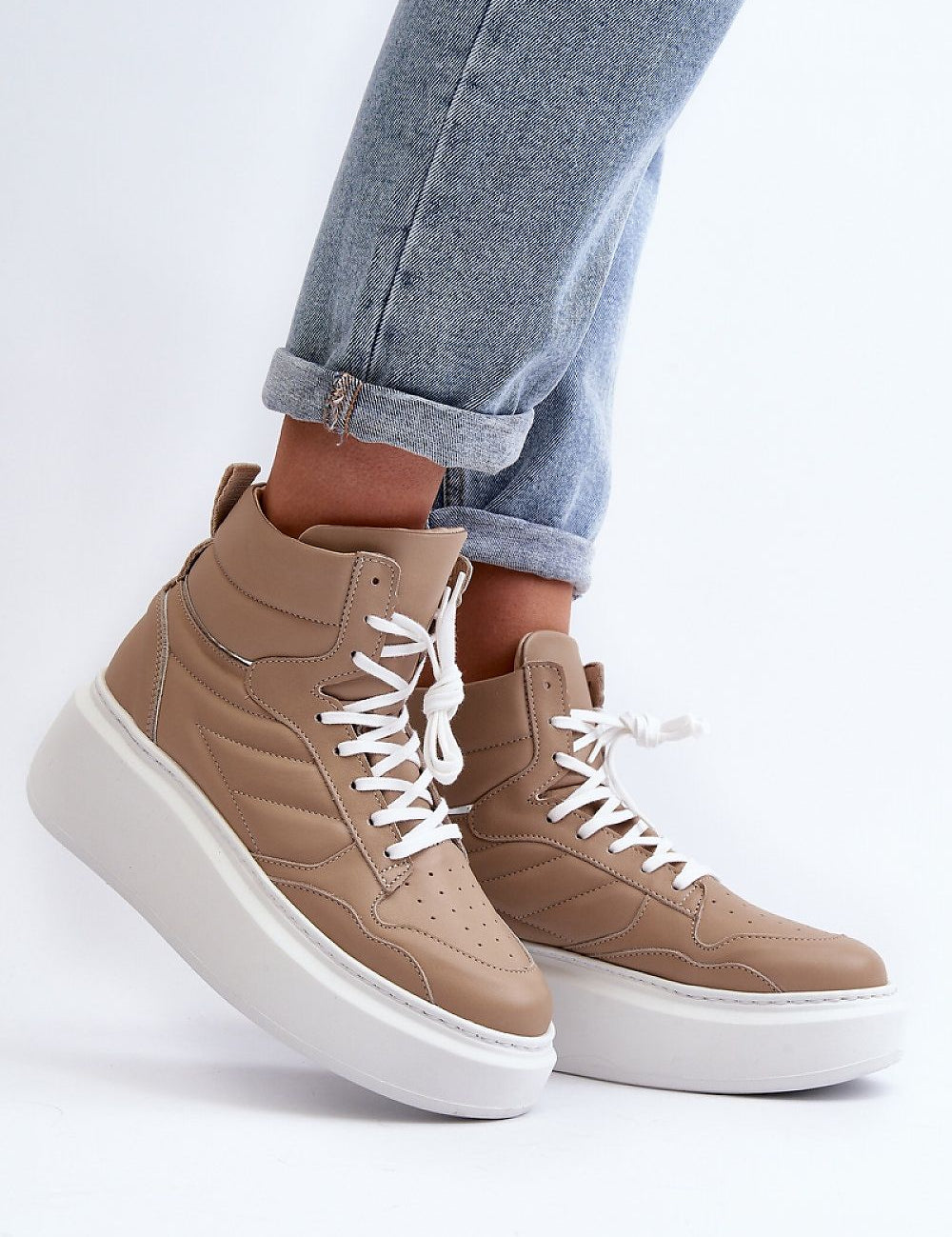 Valonne leather platform trainers with 7 cm heel, lace-up design and beige color, styled with rolled-up jeans.