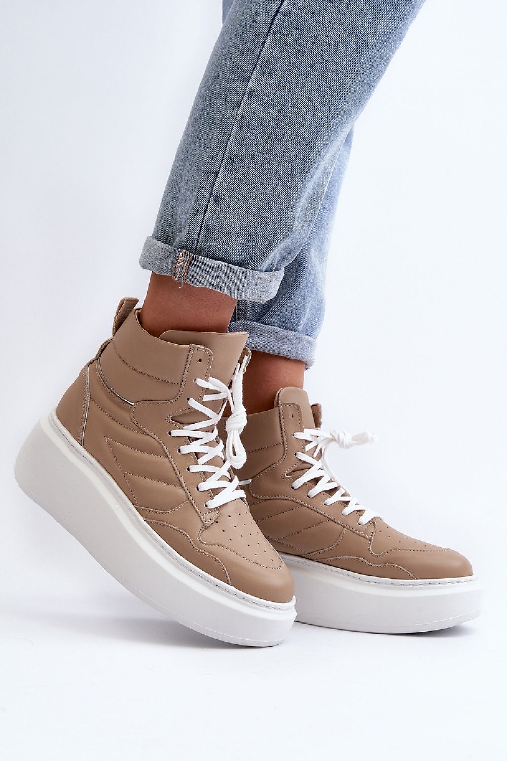 Valonne leather platform trainers with 7 cm heel, lace-up design and beige color, styled with rolled-up jeans.