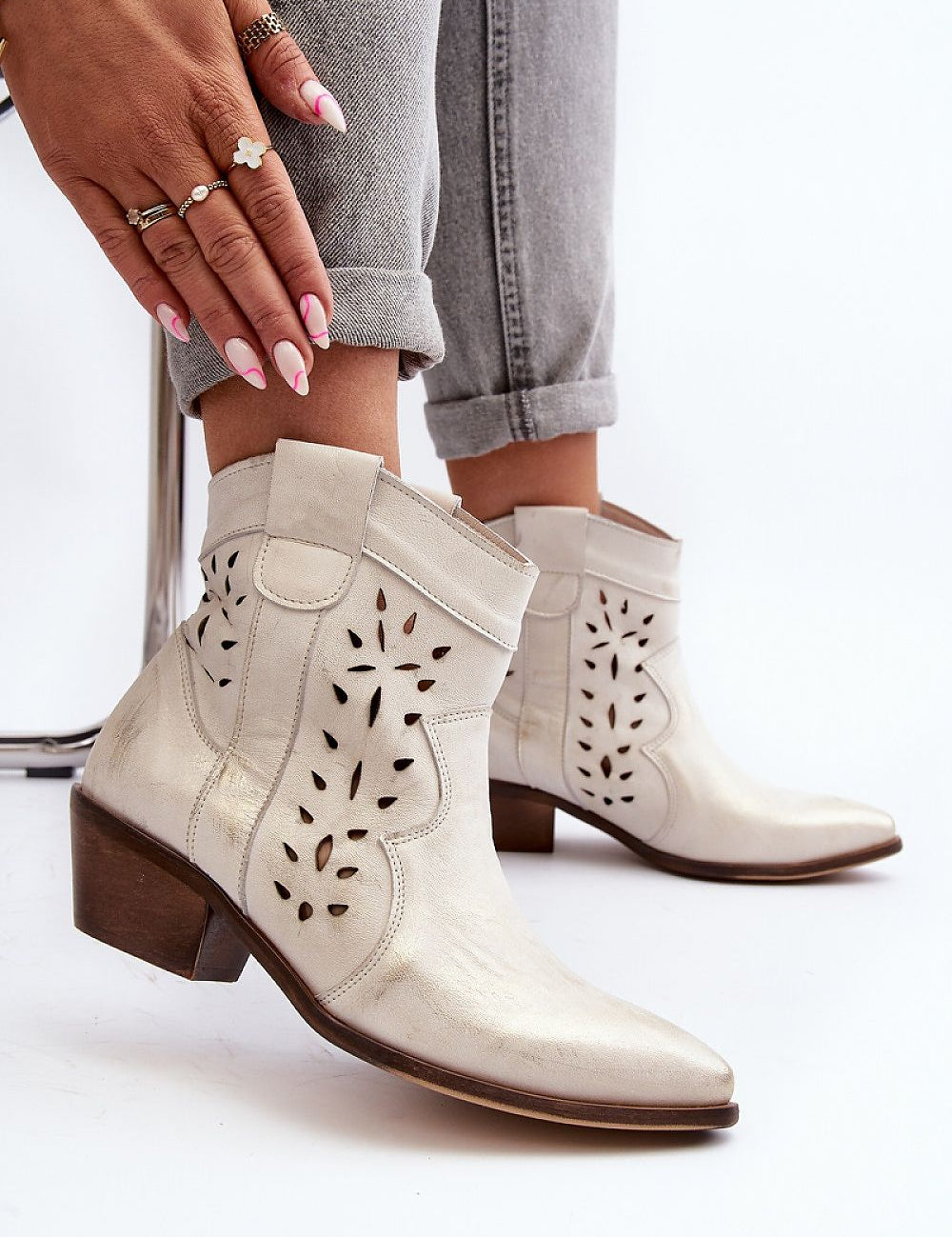 Woman wearing Riverta Leather Western Ankle Boots in natural leather, showing pointed toe and 5 cm heel, paired with grey rolled-up jeans.
