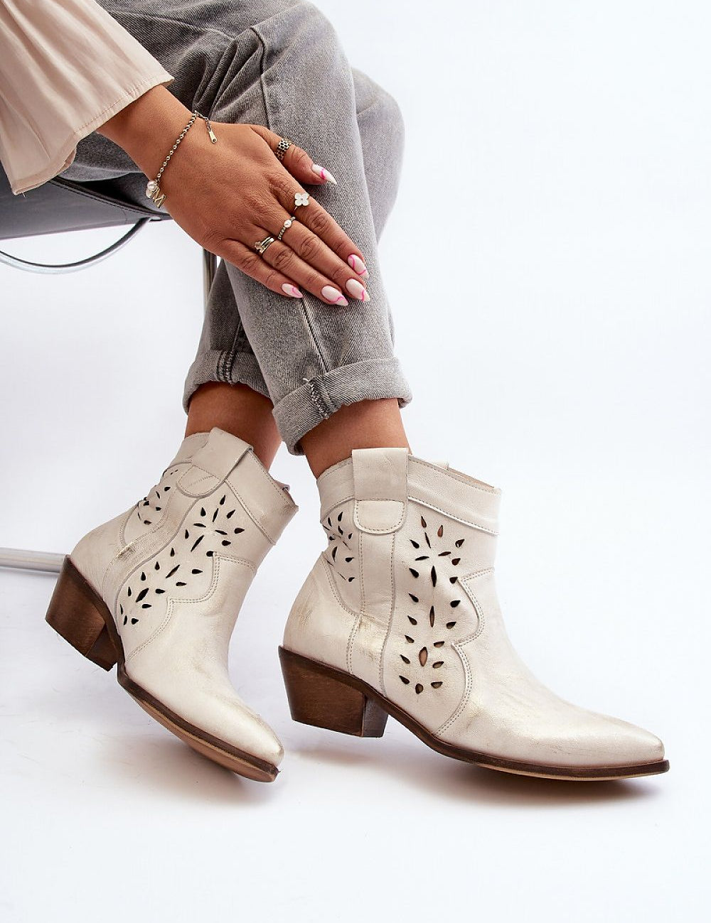 Woman wearing Riverta Leather Western Ankle Boots with jeans, showcasing pointed toe and sturdy heel design for style and comfort.