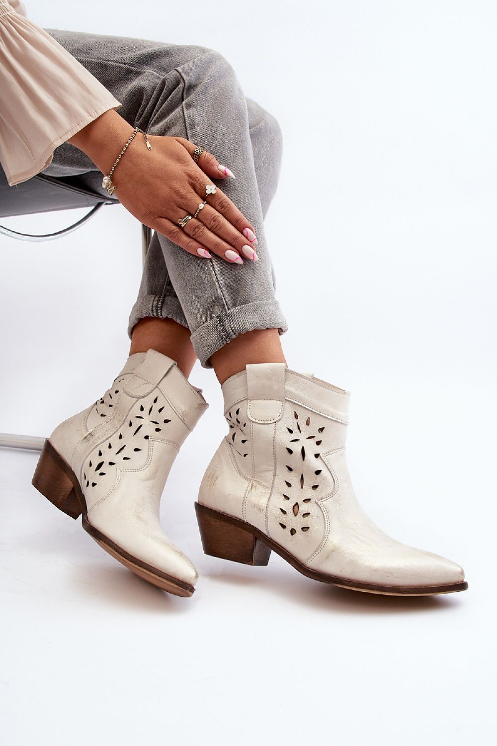 Woman wearing Riverta Leather Western Ankle Boots with jeans, showcasing pointed toe and sturdy heel design for style and comfort.