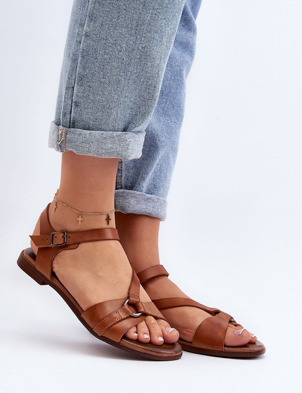 Sylvara Classic Leather Flat Sandals with adjustable strap and low heel, worn with cuffed jeans for a casual summer style.