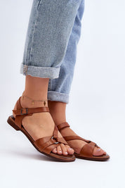 Sylvara Classic Leather Flat Sandals with adjustable strap and low heel, worn with cuffed jeans for a casual summer style.