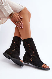 Avelynna Suede Openwork Zip Sandals with intricate detailing, black flat heel, and high zippered upper, worn by model.