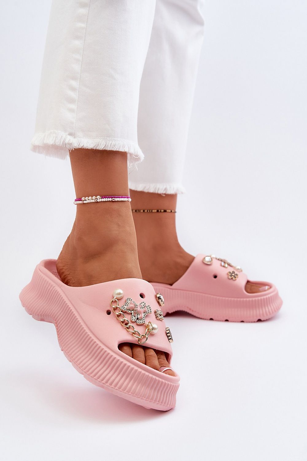 Close-up of Orminya pink foam platform slides with decorative accents, showcasing lightweight design and thick sole for comfort and height.