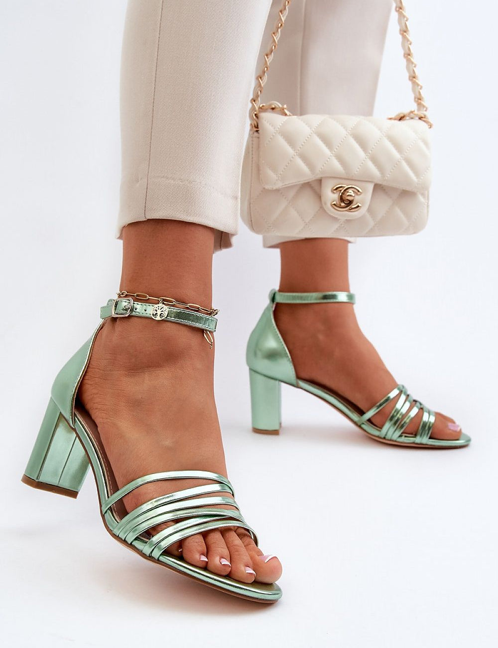 Elvarine Strappy Post Heel Sandals in mint green eco leather with delicate straps and post heel, paired with white quilted handbag.