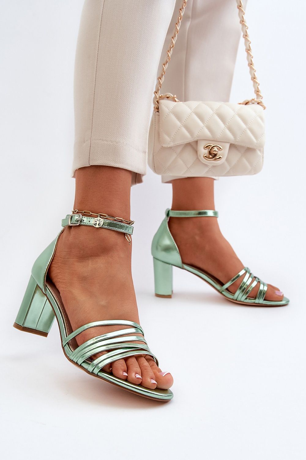 Elvarine Strappy Post Heel Sandals in mint green eco leather with delicate straps and post heel, paired with white quilted handbag.