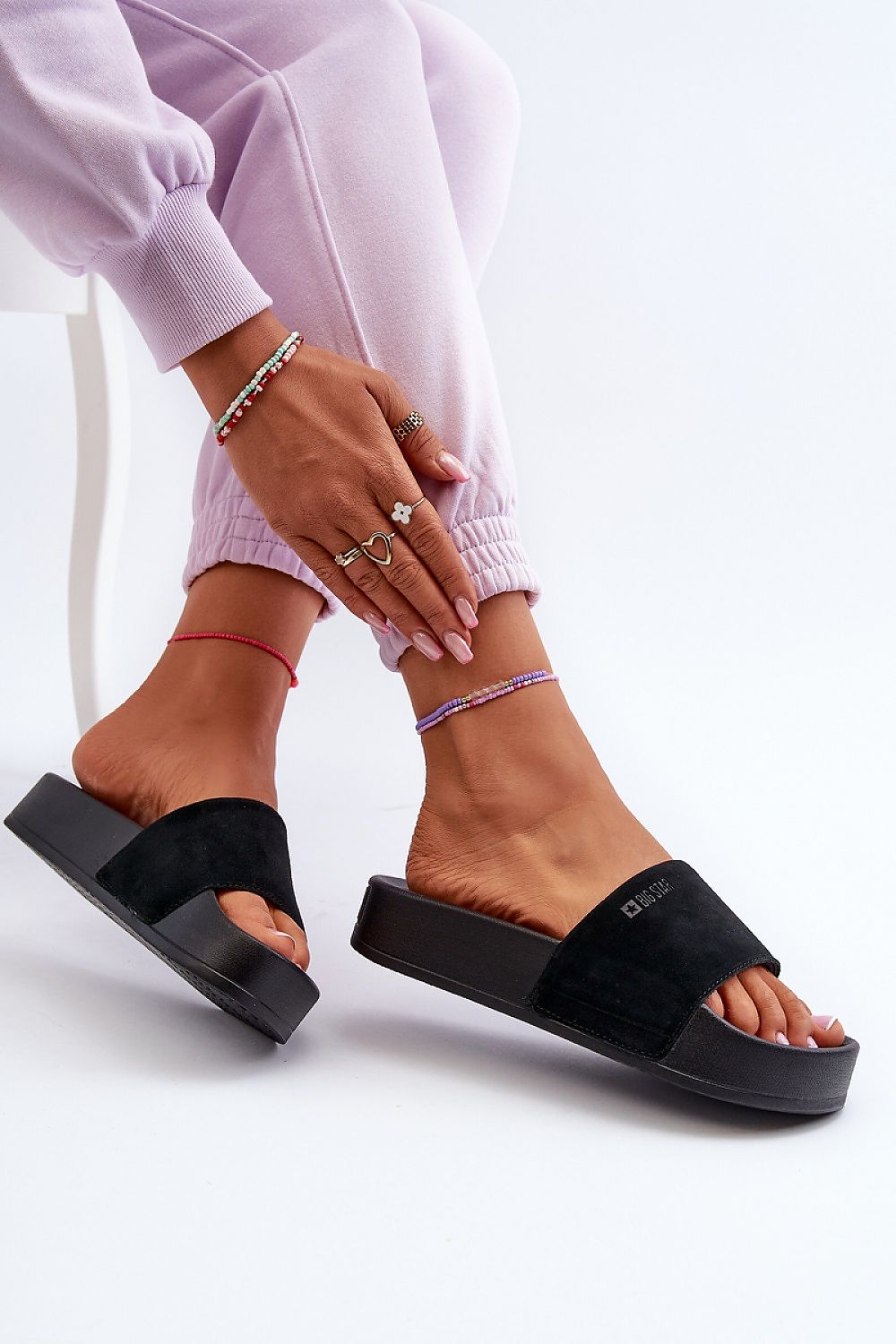 Woman wearing Zanurea suede platform slide sandals with wide strap and molded footbed, pairing with casual lavender pants.