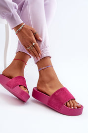 Woman wearing Zanurea pink suede platform slide sandals with a wide strap and molded footbed for casual comfort and evening style.