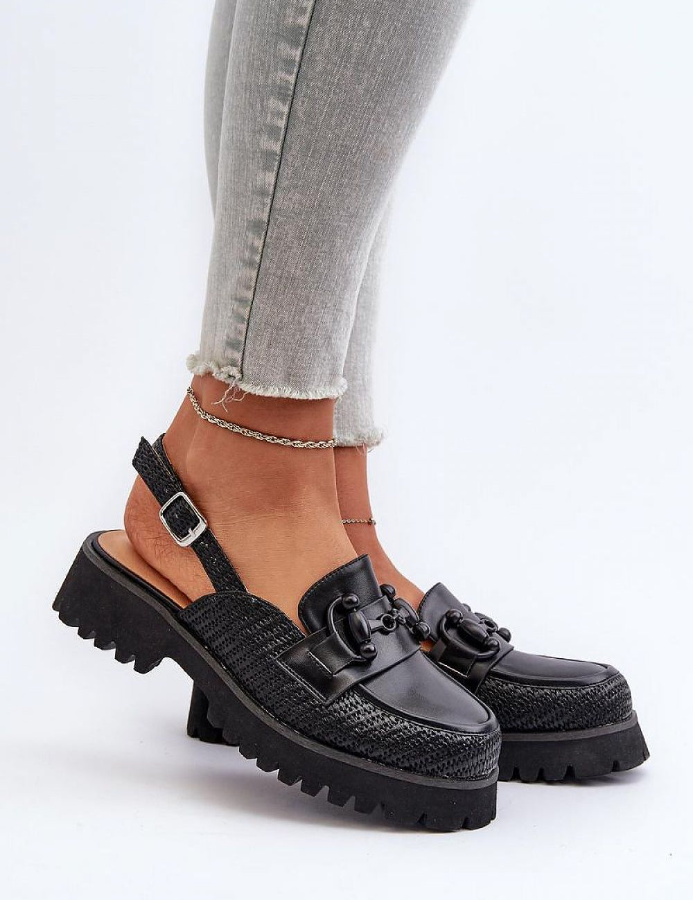 Larivena Buckled Low Platform Sandals in black eco leather with adjustable buckle, worn on feet with gray jeans, showcasing stylish comfort.