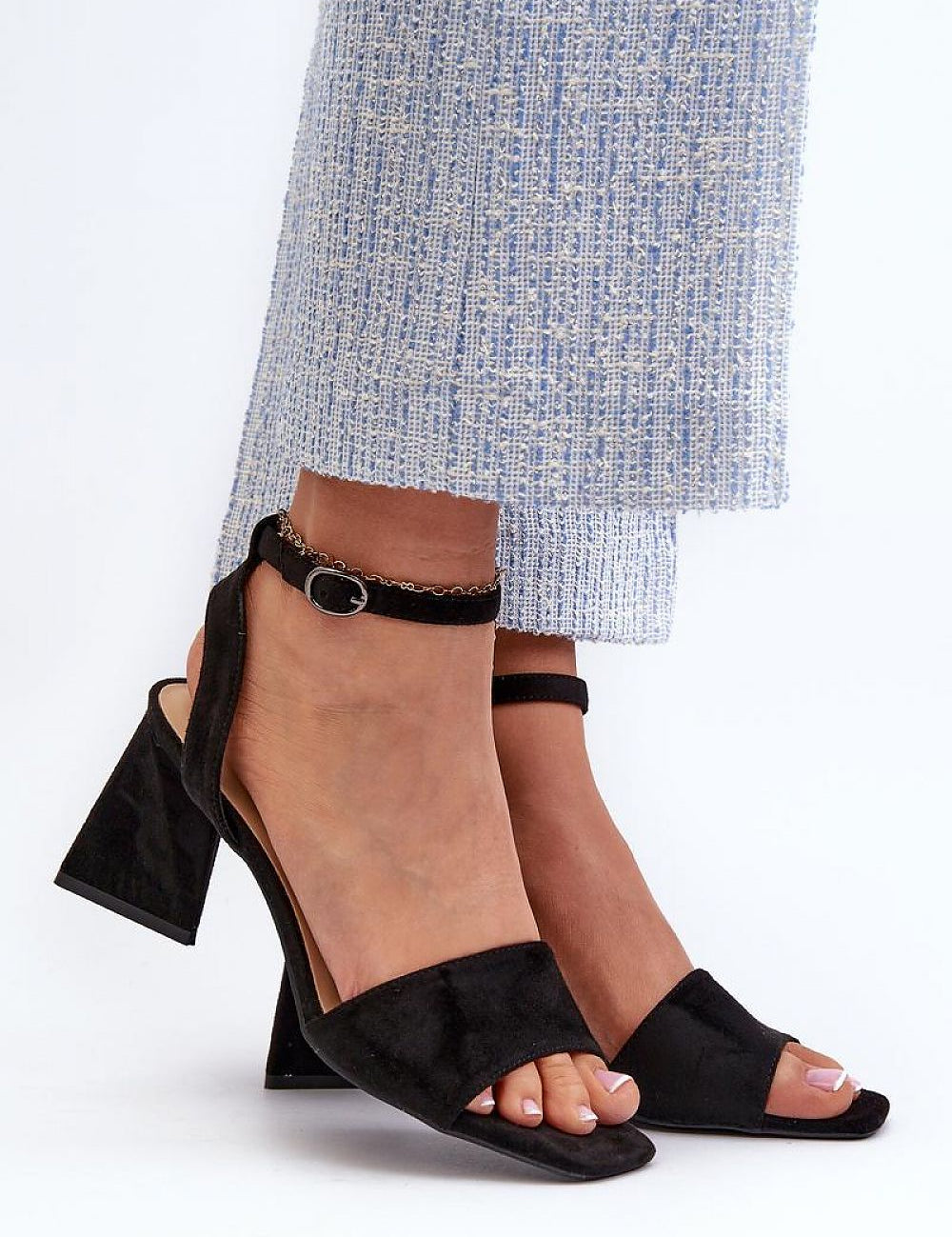 Model wearing Solavine High Suede Strap Sandals with adjustable ankle strap and block heel, paired with stylish blue textured trousers.