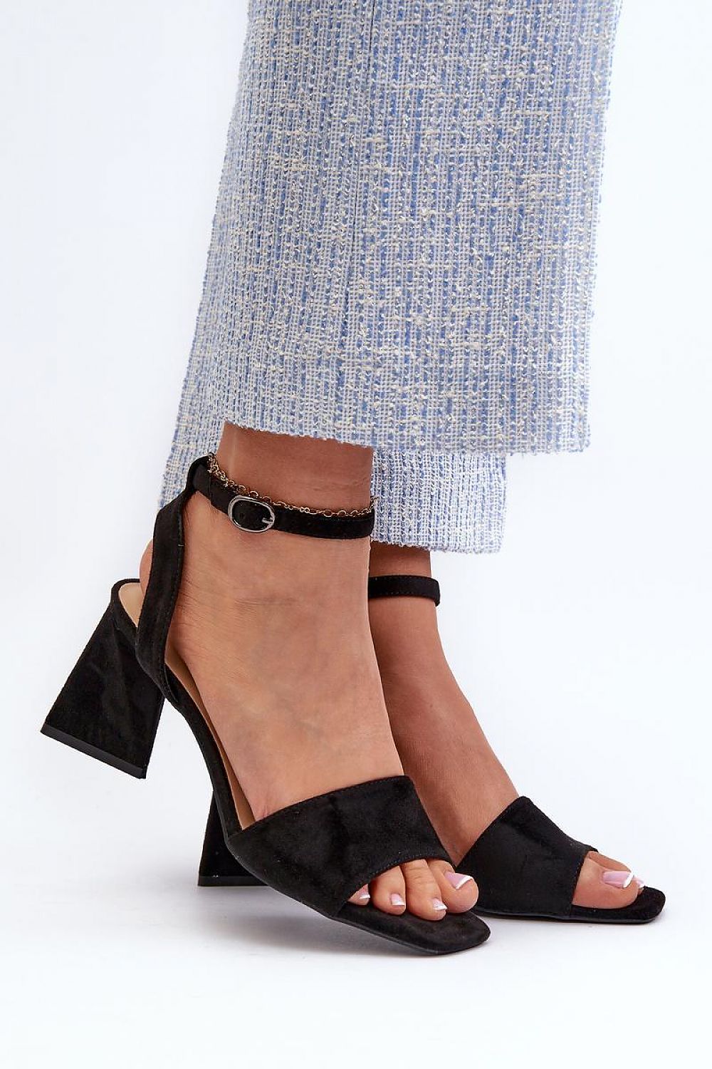 Model wearing Solavine High Suede Strap Sandals with adjustable ankle strap and block heel, paired with stylish blue textured trousers.