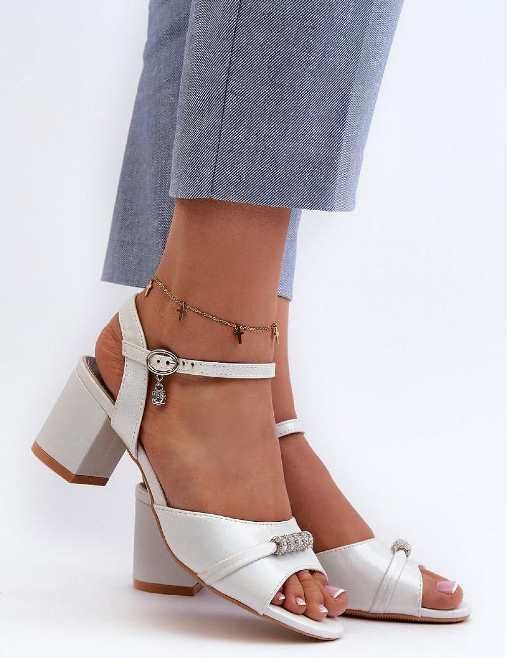 Avenari soft suede embellished sandals with a stable post heel, worn with light blue trousers, ideal for summer events.