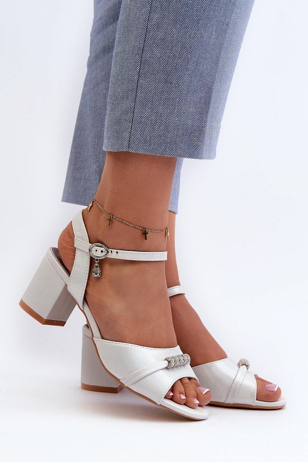 Avenari soft suede embellished sandals with a stable post heel, worn with light blue trousers, ideal for summer events.