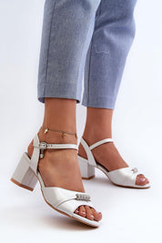 Woman wearing Avenari soft suede embellished sandals with block heels, paired with light blue jeans, showcasing elegant summer footwear.