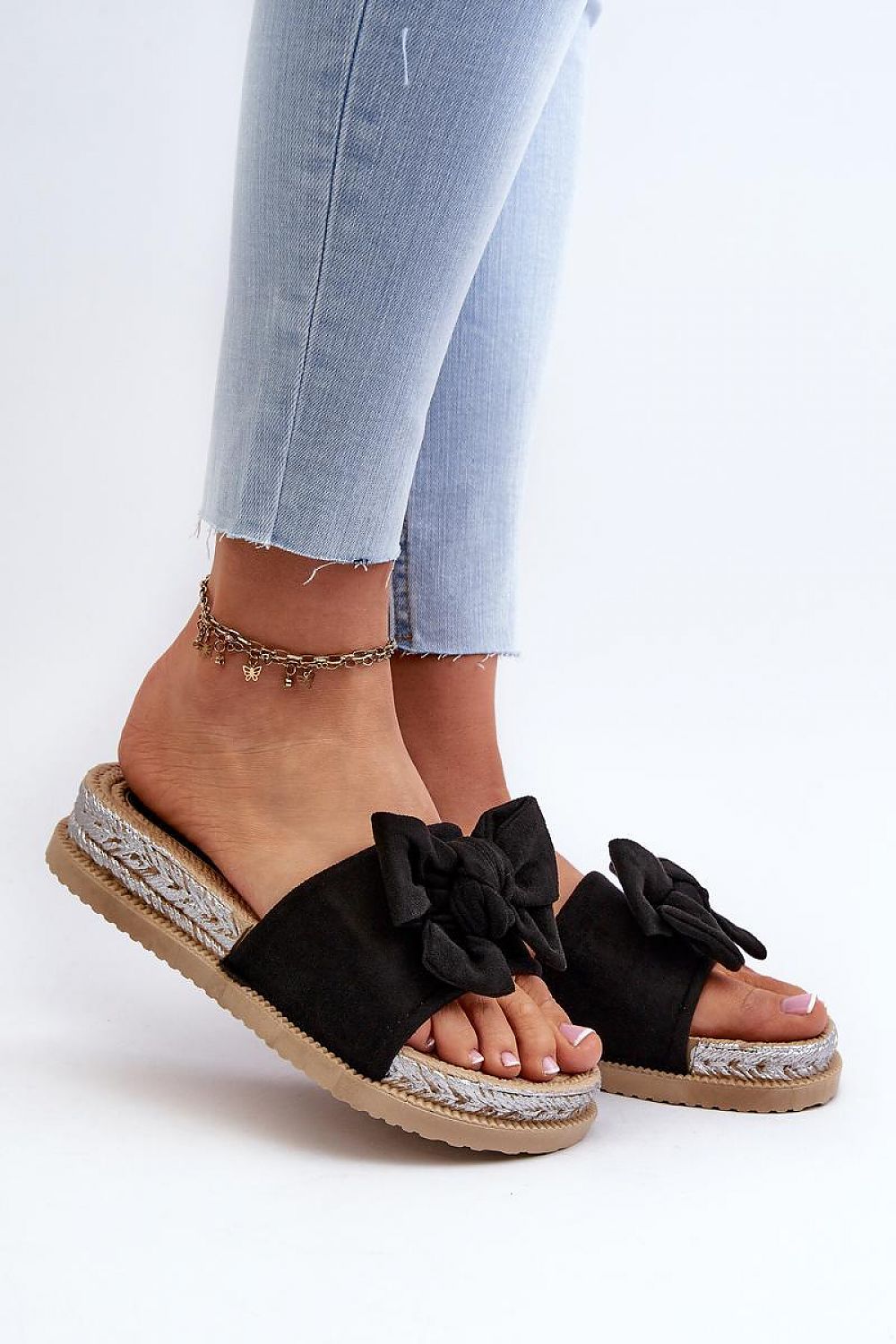 Alinara Suede Knot Platform Slides in black eco-suede, featuring a graceful bow, worn with light jeans on relaxed summer days.