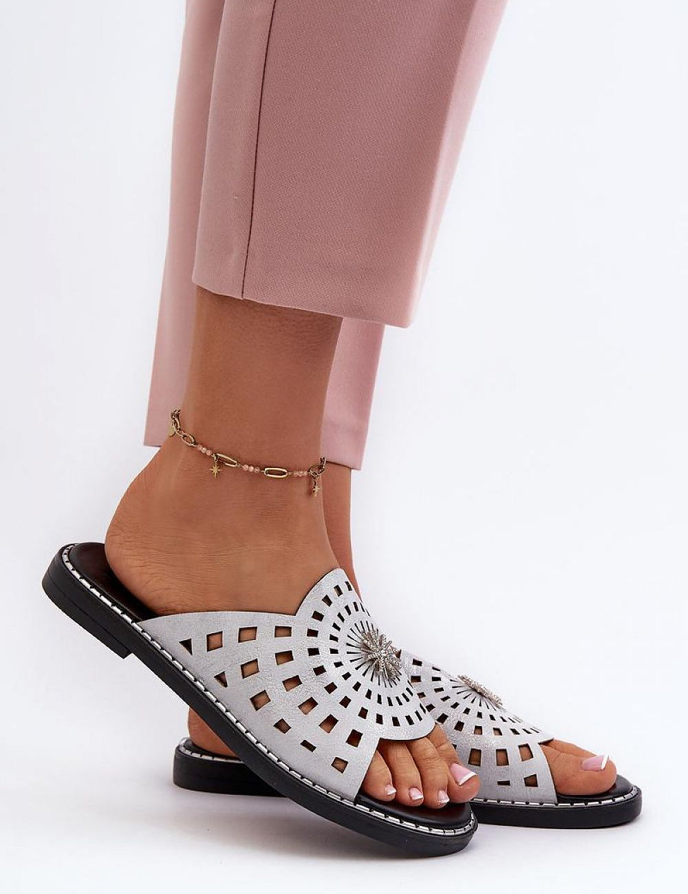 Light pink trousers paired with Orletta flat slides featuring cutout eco leather upper and low heel for comfort and style.