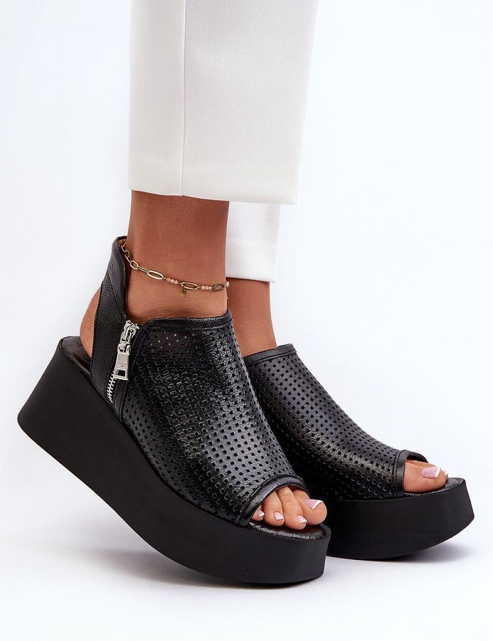 Black openwork leather platform sandals with high heel and zipper closure, perfect for summer style and elevation.