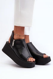 Black openwork leather platform sandals with high heel and zipper closure, perfect for summer style and elevation.